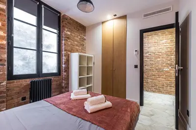 a bedroom with a bed and a brick wall at FEEL HOME - BUNICO in Nice