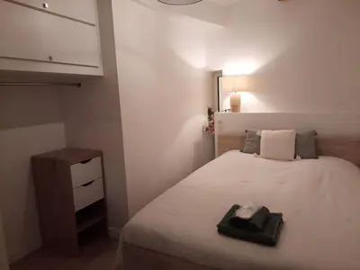 a small bedroom with a bed and a night stand at Beautiful Old Town flat, near the beach in Nice