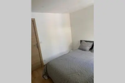 a bedroom with a bed with a gray comforter at Appartement neuf 4-6 personnes en bord de Mer in Nice