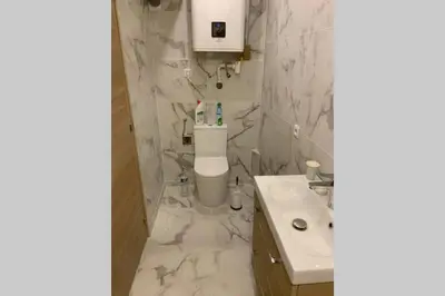 a white bathroom with a sink and a toilet at Appartement neuf 4-6 personnes en bord de Mer in Nice