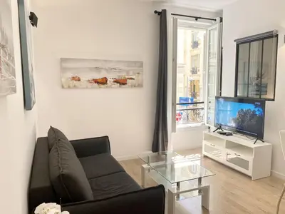a living room with a couch and a television at Central Modern Flat Lamartine in Nice