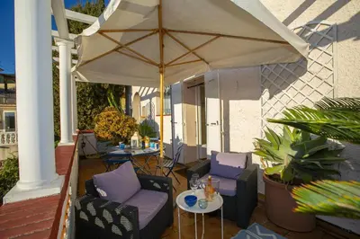 an outdoor patio with chairs and an umbrella at Villa MonTLilin - Happy Rentals in Villefranche-sur-Mer