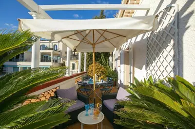 a patio with an umbrella and tables and chairs at Villa MonTLilin - Happy Rentals in Villefranche-sur-Mer