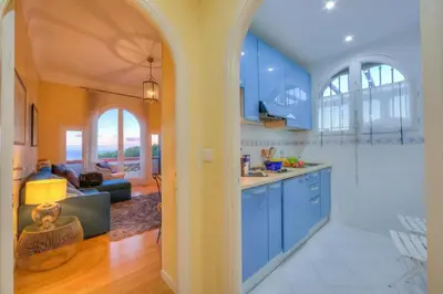 a kitchen with blue cabinets and a living room at Villa MonTLilin - Happy Rentals in Villefranche-sur-Mer