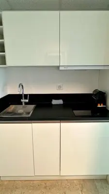 a kitchen with white cabinets and a sink at Studio Carré d'Or in Nice