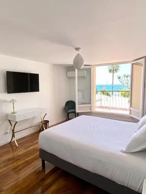 a bedroom with a bed and a desk and a window at Maison de la Marine in Cagnes-sur-Mer