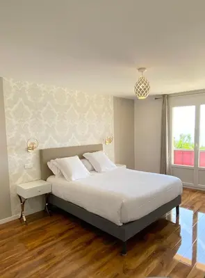 a bedroom with a large bed and a window at Maison de la Marine in Cagnes-sur-Mer