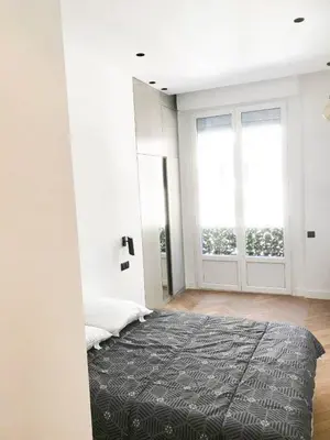 a bedroom with a bed and a large window at Buffa Résidence in Nice