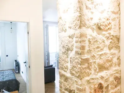 a stone wall in a room with a living room at Buffa Résidence in Nice