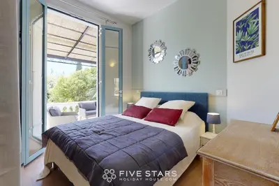 a bedroom with a bed and a large window at Villa Capriciosa - Five Stars Holiday House in Beaulieu-sur-Mer