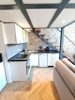 a kitchen with white cabinets and a staircase at 35m2, luminous loft close to the beach in Villefranche-sur-Mer