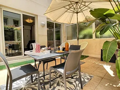 a table and chairs with an umbrella on a patio at Nestor&Jeeves - BERLIOZ PATIO - Central - Residential area - Patio 20m in Nice
