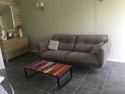 a living room with a brown couch and a coffee table at Loft 1 in La Trinité