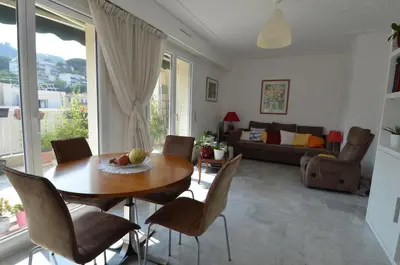 a living room with a wooden table and chairs at PHOENIX - Appartement 4 personnes avec superbe terrasse, clim et parking le port de Nice in Nice