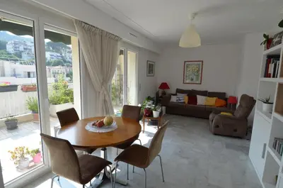 a living room with a wooden table and chairs at PHOENIX - Appartement 4 personnes avec superbe terrasse, clim et parking le port de Nice in Nice
