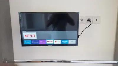 a tv on a wall with a picture of a person at NEW CHEAP PRIVATE ROOM, KITCHEN , OVERWIEUW sea,TRAM on spot, 12 minutes from nice train station with tram , beach in 17 min tram , CHAMBRE PRIVÉE pas cher, cuisine équipée , tram sur place, APERÇU mer, 12 min de la gare de Nice avec le tram, 17 min plage in Nice