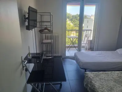 a bedroom with a bed and a table and a balcony at NEW CHEAP PRIVATE ROOM, KITCHEN , OVERWIEUW sea,TRAM on spot, 12 minutes from nice train station with tram , beach in 17 min tram , CHAMBRE PRIVÉE pas cher, cuisine équipée , tram sur place, APERÇU mer, 12 min de la gare de Nice avec le tram, 17 min plage in Nice