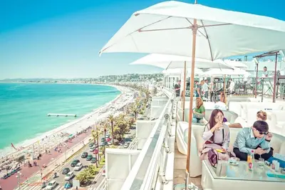 a group of people sitting on a balcony overlooking the beach at Superbe studio sur Nice in Nice