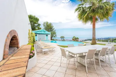 a patio with a table and chairs and a pool at VILLA NICE-GAIRAUT by RIVIERA HOLIDAY HOMES in Nice