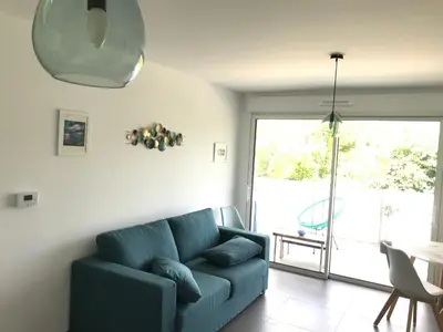 a living room with a blue couch and a sliding glass door at Appartement à Nice in Nice