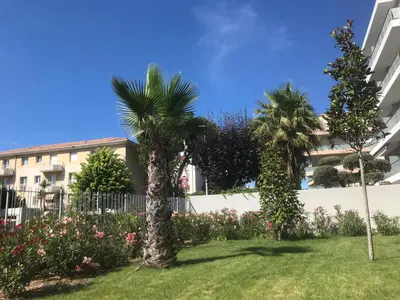 two palm trees in a yard in front of a building at Appartement à Nice in Nice