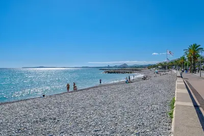 a beach with a crowd of people and the ocean at Studio de la plage - Mer, Terrasse et garage in Cagnes-sur-Mer