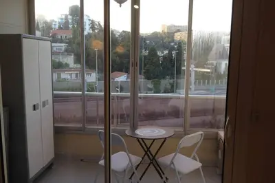 a table and two chairs in front of a window at Beau Studio à 50m de la plage in Nice