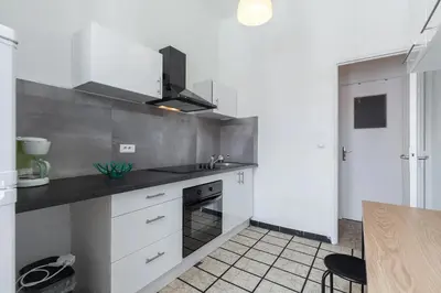a white kitchen with a sink and a stove at FEEL HOME - ASSALIT in Nice