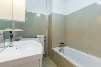 a white bathroom with a tub and a sink at FEEL HOME - ASSALIT in Nice