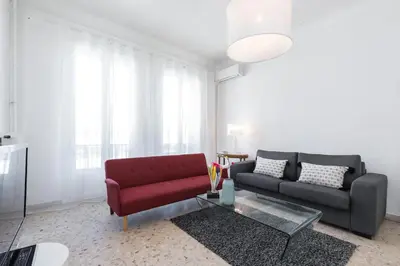 a living room with a red couch and a table at FEEL HOME - ASSALIT in Nice