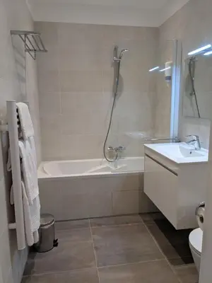 a bathroom with a tub and a sink and a toilet at Share Inn Appartements in Nice