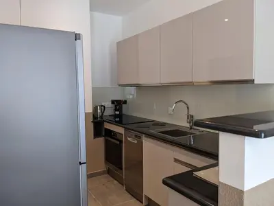 a kitchen with white cabinets and stainless steel appliances at Share Inn Appartements in Nice