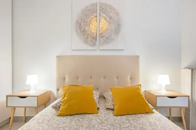a bedroom with a bed with yellow pillows and two lamps at Stunning flat by the beach, Carre d'or-Negresco in Nice