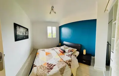a bedroom with a bed with a blue wall at Spacieux/paisible 5 pièces en plein coeur de Nice in Nice