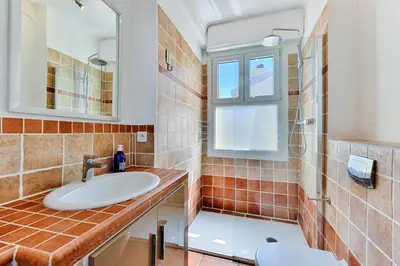 a bathroom with a sink and a shower and a mirror at La terrasse de Rossini in Nice