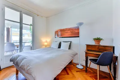 a bedroom with a bed and a desk and a window at La terrasse de Rossini in Nice