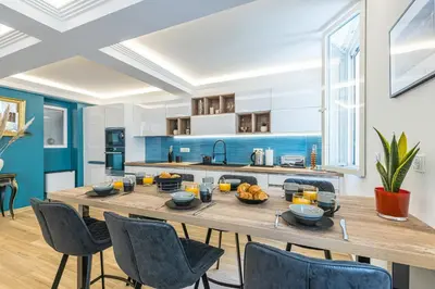 a kitchen with a large wooden table and chairs at Luxury 3 Bdr Garden & Parking - Angels' Garden in Nice