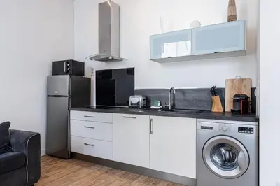 a kitchen with a washer and a sink and a refrigerator at Bright 1 Bdr in the Old Town in Nice
