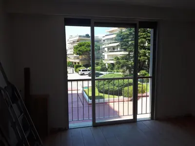an open door to a balcony with a view of a building at Studio bord de mer in Saint-Laurent-du-Var