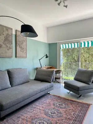 a living room with a couch and a table at Air-conditioned apartment with garage near the sea in Nice