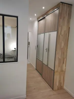 a hallway with a wooden door and a mirror at Halévy Résidence in Nice