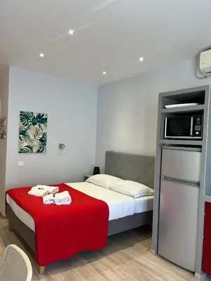 a bedroom with a bed with a red blanket at Red studio Buffa in Nice