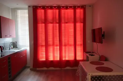 a kitchen with red curtains in a red kitchen at Red studio Buffa in Nice