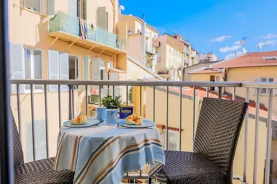 a table with two plates of food on a balcony at SUEDE 3 AP4209 By Riviera Holiday Homes in Nice