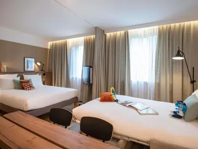 a bedroom with a bed with white pillows at Novotel Suites Nice Airport in Nice