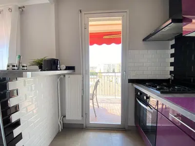 a kitchen with a door leading to a balcony at Stylish Modern Beach Studio in Nice