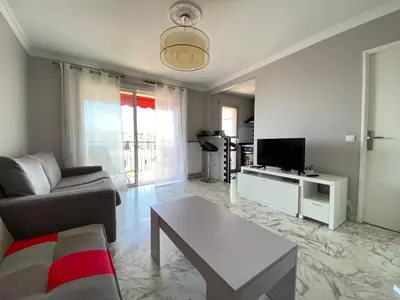 a living room with a couch and a tv at Stylish Modern Beach Studio in Nice