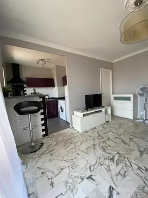 a living room with a marble floor with a bar stool at Stylish Modern Beach Studio in Nice