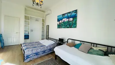 a bedroom with two beds and a painting on the wall at Spacious 3 BR flat Nice center - magnificent view in Nice