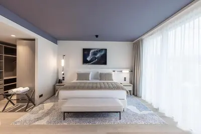 a bedroom with a large bed with a blue ceiling at Hotel Indigo Cagnes-sur-Mer by IHG in Cagnes-sur-Mer